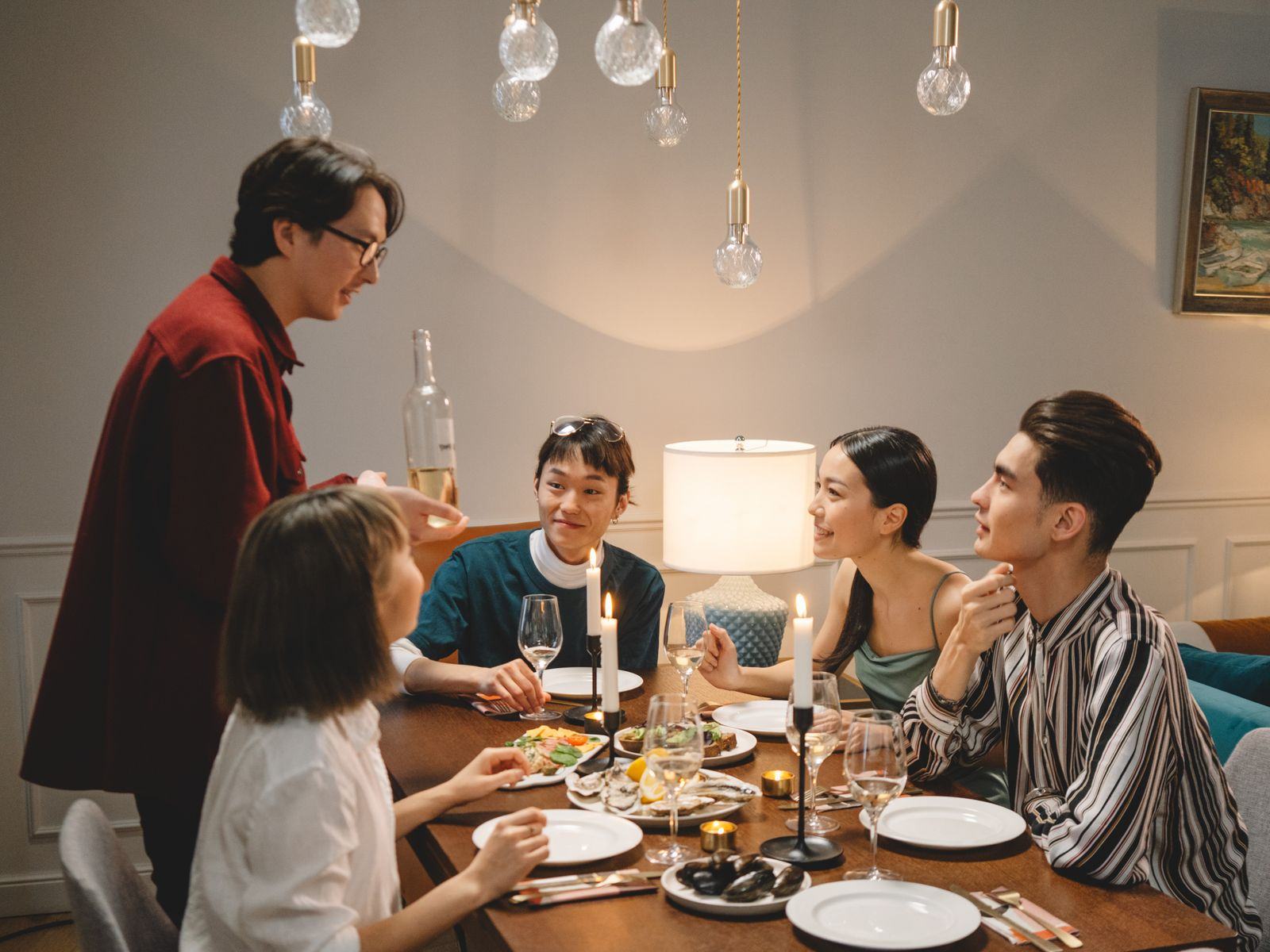 Un dîner entre convives autour d'une table, à la lueur des bougies